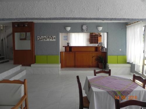 a dining room with a table and a kitchen at Hotel Lena in Limenas