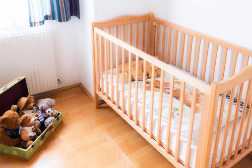 a crib with a bunch of stuffed animals in it at Der Torwirt Radstadt in Radstadt