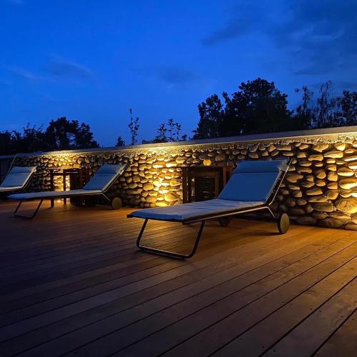 two lounge chairs on a deck at night at La Maison de Paul & Margaux in Châteauneuf-de-Galaure