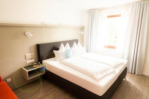 a bedroom with a large white bed with a window at Der Torwirt Radstadt in Radstadt
