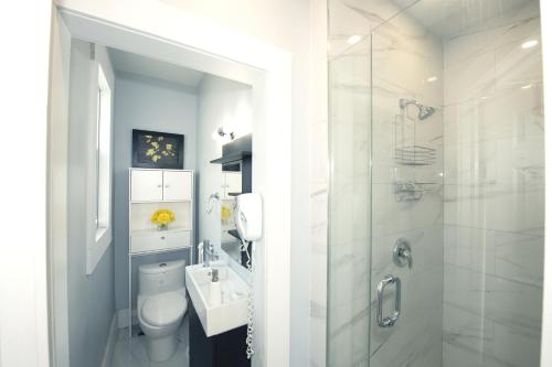 a bathroom with a toilet and a sink and a shower at Serene Niagara Inn in Niagara Falls