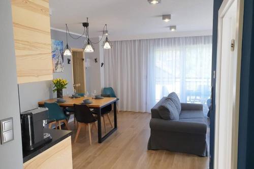 un soggiorno con divano e tavolo da pranzo di RelaxApart - Komfortowy apartament z prywatną sauną a Szczyrk