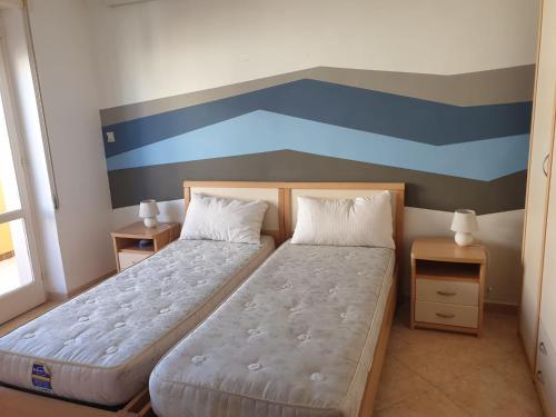 ガリポリにあるAttico In Riva al Mareのベッドルーム1室(ベッド2台付)が備わります。壁には絵画が飾られています。