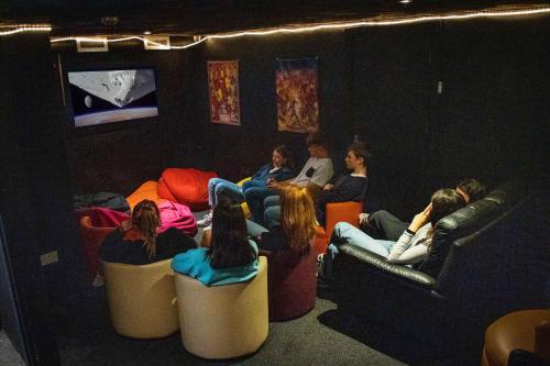 a group of people sitting in a room watching a movie at Sheilas Tourist Hostel in Cork