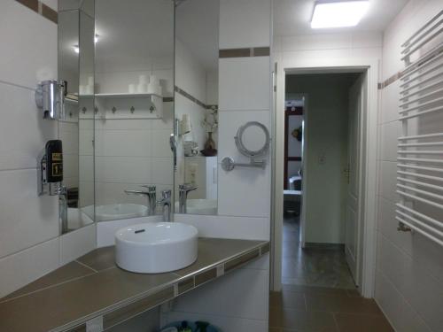 a white bathroom with a sink and a mirror at Gästehaus Daheim in Lohme