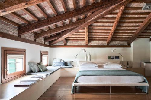 1 dormitorio con cama grande y techo de madera en Venissa Wine Resort, en Burano