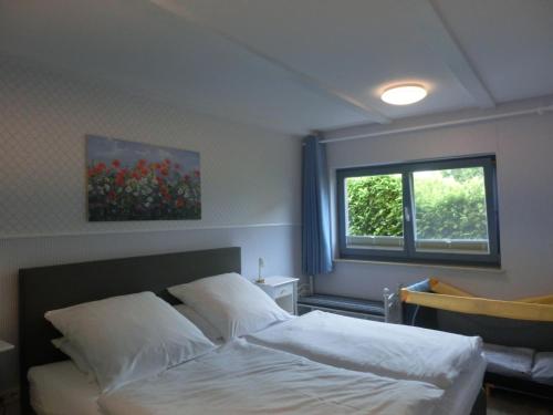 a bedroom with a bed and a window at Gästehaus Daheim in Lohme