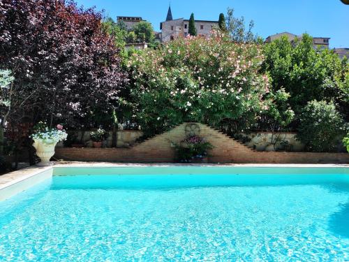 einen Pool vor einem Garten mit Blumen in der Unterkunft Villamena in Spello
