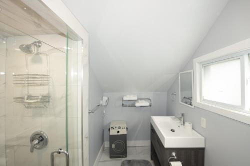 a white bathroom with a shower and a sink at Serene Niagara Inn in Niagara Falls