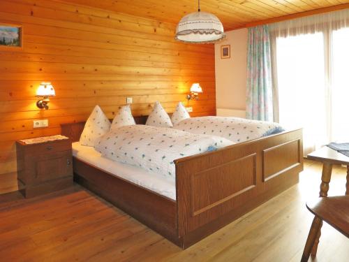 sypialnia z dużym łóżkiem i drewnianymi ścianami w obiekcie Apartment Haus Corinna - GOP230 by Interhome w mieście St. Gallenkirch