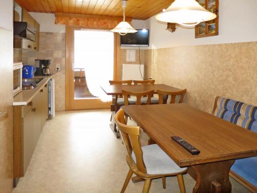 una cucina e una sala da pranzo con tavolo e sedie in legno di Apartment Haus Corinna - GOP230 by Interhome a Sankt Gallenkirch