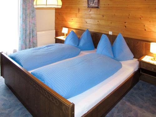 una camera con 2 letti con cuscini blu di Apartment Haus Corinna - GOP230 by Interhome a Sankt Gallenkirch