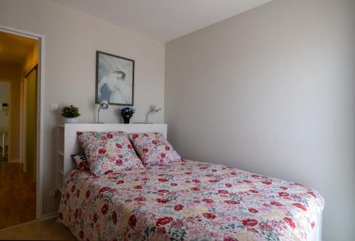 コルマールにあるCOLMAR SWEET HOMEのベッドルーム1室(花柄の掛け布団付きのベッド1台付)