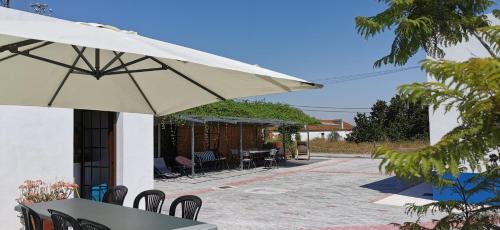 a patio area with a patio umbrella and chairs at Retiro dos Batudes in Palmela