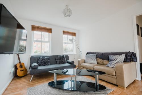 ein Wohnzimmer mit einem Sofa und einem Tisch in der Unterkunft Hullidays - Victoria Dock Residence in Hull