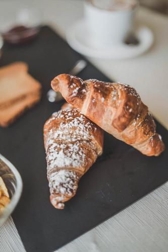 two croissants on a black plate on a table at Hotel Niagara in Catanzaro Lido