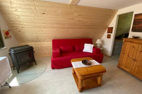 a living room with a red couch and a stove at Matilda II - lovely Matilda in Wesenberg