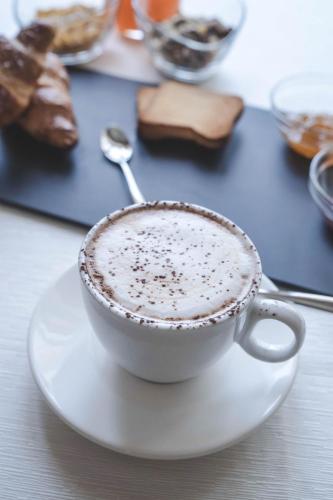 a cup of coffee on a plate with a spoon at Hotel Niagara in Catanzaro Lido