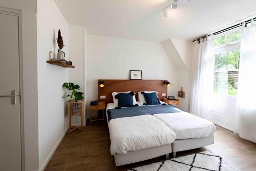 sypialnia z dużym łóżkiem z niebieskimi poduszkami w obiekcie Hofstede Villetta w mieście Zonnemaire