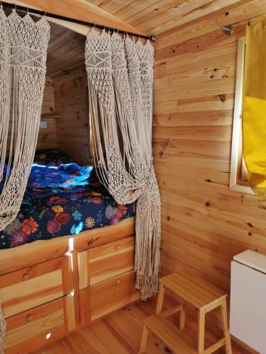 - une chambre dans une cabane en rondins dotée de rideaux dans l'établissement Roulotte la clé du Luberon, à Buoux