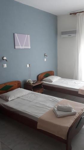 a bedroom with two beds and a window at Hotel Lena in Limenas