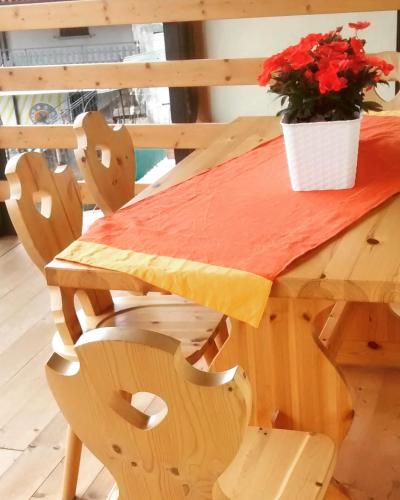 a wooden table with a pot of flowers on it at Ostello Sociale Borgo Venno in Lavenone