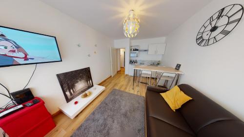 un salon avec un canapé et une télévision dans l'établissement Aux bons amis - Parlement/Orangerie, à Strasbourg