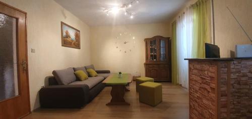 ein Wohnzimmer mit einem Sofa und einem Tisch in der Unterkunft Apartments New Charming in Senj