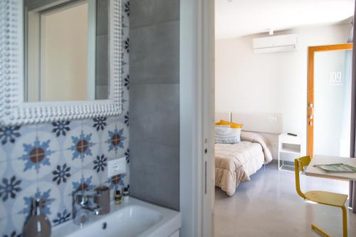 a bathroom with a sink and a bed in a room at Guest House Bella Onda in Tessera