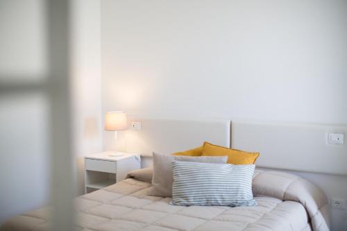 a bedroom with a bed with pillows and a lamp at Guest House Bella Onda in Tessera