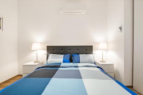 ein Schlafzimmer mit einem blauen und weißen Bett mit zwei Lampen in der Unterkunft A pochi minuti da Fiera Bologna Apartment in Bologna