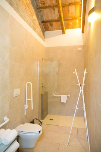 a bathroom with a toilet and a shower with a glass door at Guest House Bella Onda in Tessera