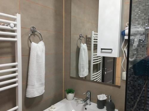 ein Bad mit einem Waschbecken und einem Spiegel in der Unterkunft Vila Amy in Năvodari
