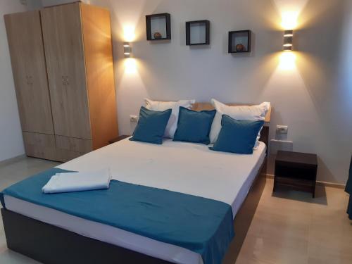 ein Schlafzimmer mit einem großen Bett mit blauen Kissen in der Unterkunft Vila Amy in Năvodari