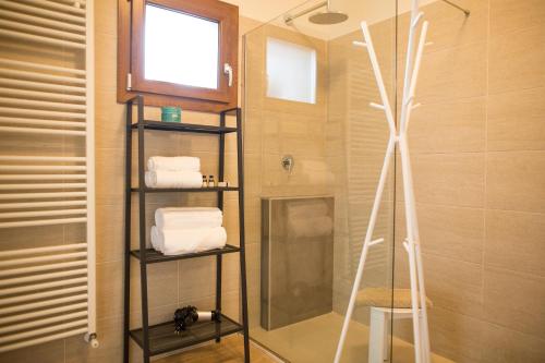 a bathroom with a shower and a shelf with towels at Guest House Bella Onda in Tessera
