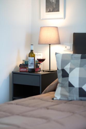 a bed with a bottle of wine and a lamp at Guest House Bella Onda in Tessera