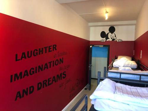 a room with two beds and a red wall at Antwerp City Hostel in Antwerp