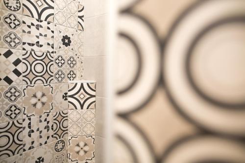 a bathroom with tiles on the wall and a mirror at Guest House Bella Onda in Tessera