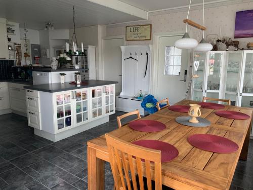 a kitchen with a wooden table and a dining room at Villa Tullgatan Borgholm in Borgholm
