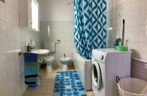 ein Badezimmer mit einer Waschmaschine und einer Waschmaschine in der Unterkunft Apartment Agava Istria - family vacation rental with free parking, garden, WiFi in Ližnjan