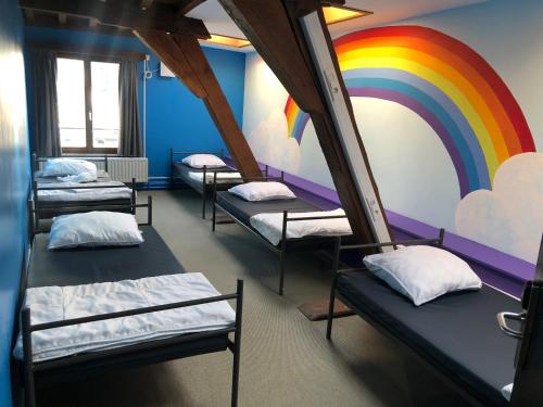 a room with four beds with a rainbow painted on the wall at Antwerp City Hostel in Antwerp