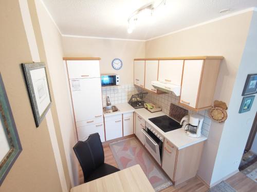 an overhead view of a small kitchen with white cabinets at Ferienparadies Gutounik in Pörtschach am Wörthersee
