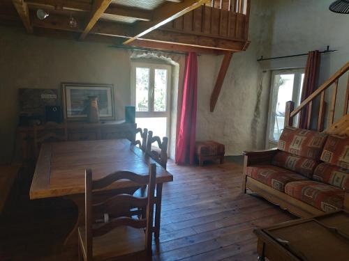 un salon avec une table en bois et un canapé dans l'établissement La Ferme Ranc - gite le couchant, à Gagnières