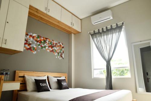 a bedroom with a bed and a window at Tuju WK Homes Syariah in Jakarta