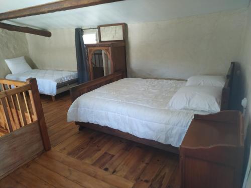 une chambre avec deux lits et un miroir dans l'établissement La Ferme Ranc - gite le couchant, à Gagnières