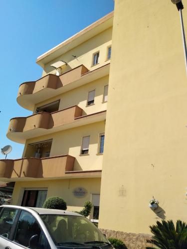 ein Gebäude mit einem davor geparkt in der Unterkunft casa vacanze di Genova Damiano in Marina di Schiavonea