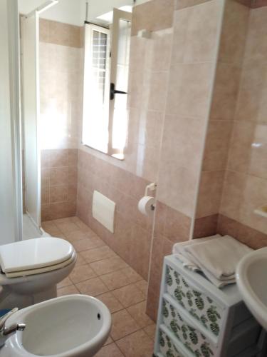 ein Bad mit einem WC, einem Waschbecken und einer Dusche in der Unterkunft casa vacanze di Genova Damiano in Marina di Schiavonea