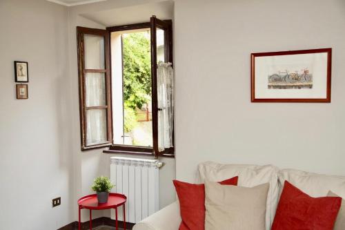 a living room with a white couch and a window at Contempora Apartments - Ca' Brenta Dudù in San Fedele Intelvi