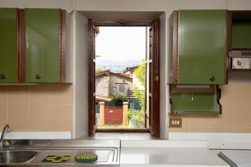 cocina con ventana, fregadero y encimera en Contempora Apartments - Ca' Brenta Dudù, en San Fedele Intelvi