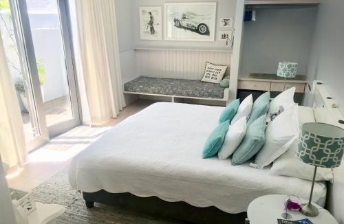 1 dormitorio con 1 cama con almohadas azules y blancas en Himmelblau Boutique Bed and Breakfast, en Ciudad del Cabo